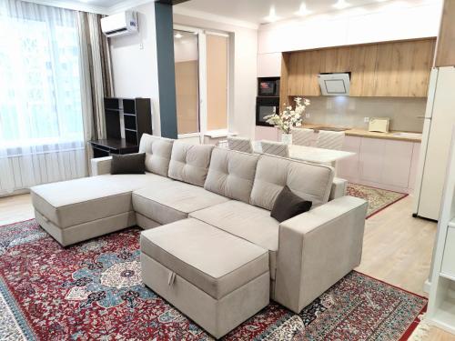een woonkamer met een bank en een tafel bij ЖК-Jazz квартал 3-х комнатная Бизнес класс in Alma-Ata