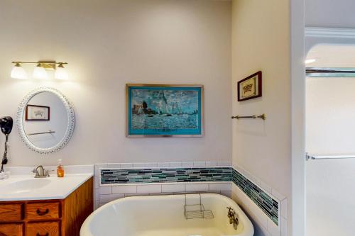 a bathroom with a tub and a sink and a mirror at Still Waters in Moneta