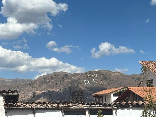 uma vista para uma montanha com um sinal sobre ela em Qosqollay Plaza de armas em Cusco