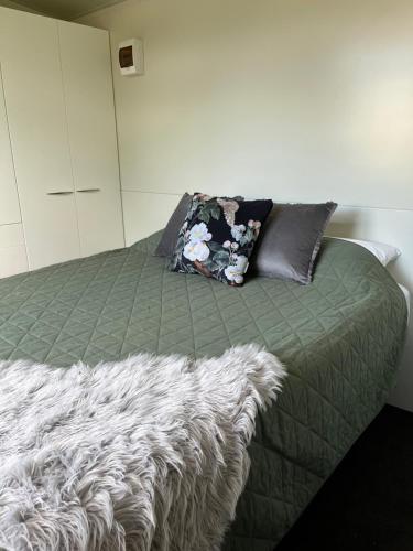 a bedroom with a bed with a blanket and a pillow at Suite Ten10 in Te Awamutu