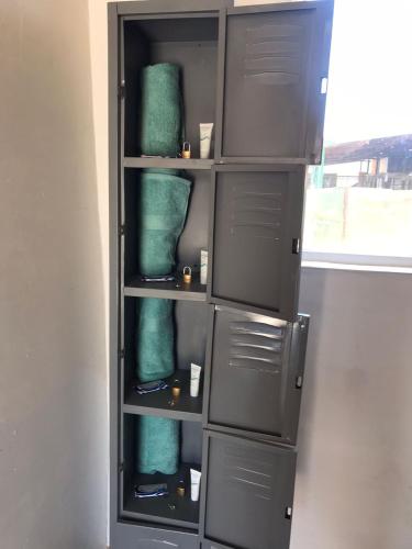 a book shelf with green towels in it at Checkpoint in Rosarito