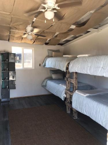 a room with three bunk beds and a ceiling fan at Checkpoint in Rosarito