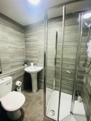 a bathroom with a shower and a toilet and a sink at Roomello City Studios in Peterborough