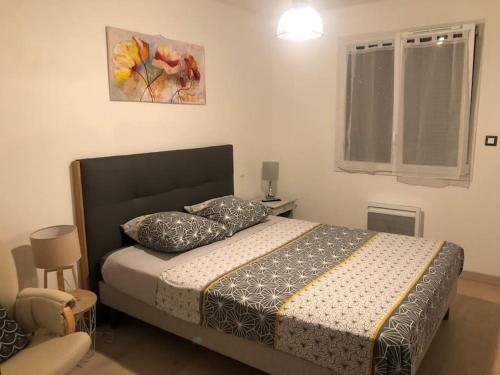 een slaapkamer met een bed met 2 kussens erop bij Pavillon récent avec 3 chambres in La Brionne