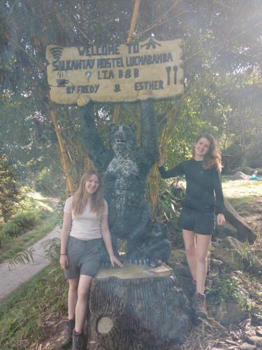 two girls are standing in front of a statue at Lia B&B Lucmabamba in Sahuayacu