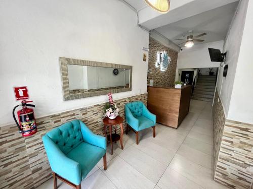 a waiting room with two blue chairs and a table at Hotel Juarez 70 in Colima