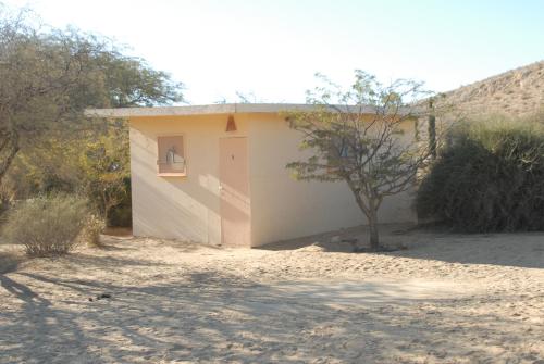 a small house with a door in the desert at Negev Camel Ranch in Dimona