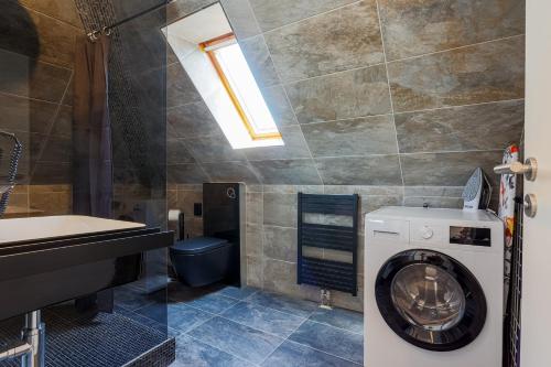 a bathroom with a washing machine and a sink at DreamStay Augsburg Traum Penthouse Göggingen in Augsburg