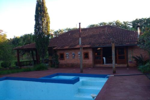una casa con una piscina azul delante de ella en Casa de Campo em Santa Rosa - RS, en Santa Rosa