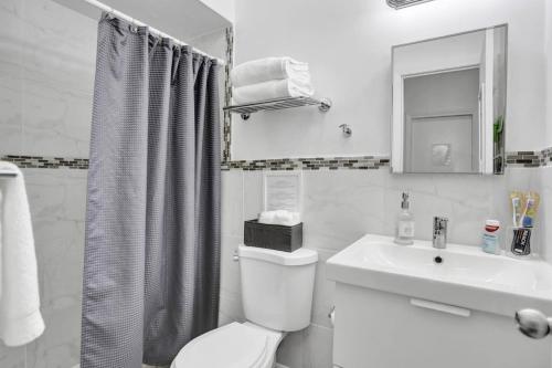 a white bathroom with a toilet and a sink at Cozy Studio Apartment in Miami