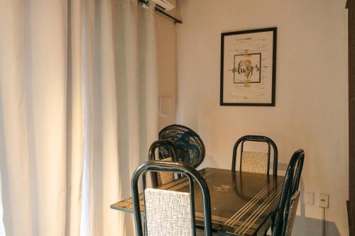 a dining room with a table and chairs next to a window at Apartamentos Mandala in Itacaré