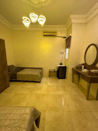 a room with a bed and a vanity and a mirror at ملحق in Taif