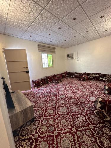 an empty room with a large red carpet at ملحق in Taif