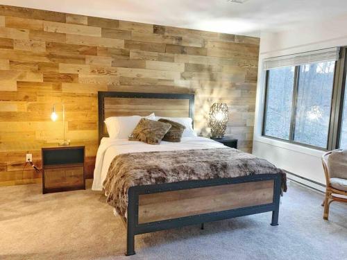 - une chambre avec un lit et un mur en bois dans l'établissement Luxe 10 guest Ski Cabin Pools/Golf/Tennis/Gym/Hike, à Vernon Township