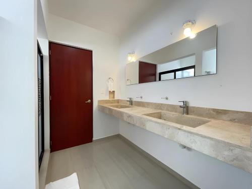 a bathroom with two sinks and a mirror at Casa Dzitya in Mérida
