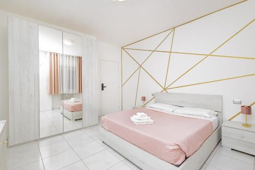 a white bedroom with a large bed and a bathroom at Holidays in Lecco