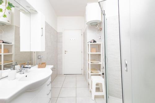 a white bathroom with two sinks and a shower at Holidays in Lecco