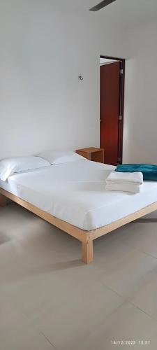 a large white bed in a room with at Casa Dzitya in Mérida