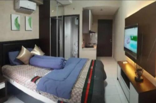 a bedroom with a bed and a flat screen tv at Apt m34 square by kiiw in Bandung
