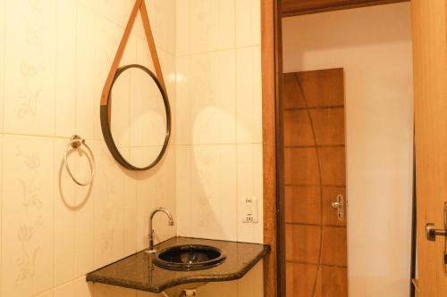 bagno con lavandino e specchio a parete di Apartamento Pituba Jardim a Itacaré