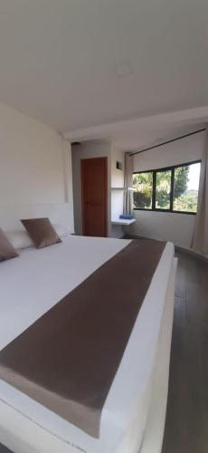a bedroom with a white bed and a window at La Manola Finca Hotel in Doradal