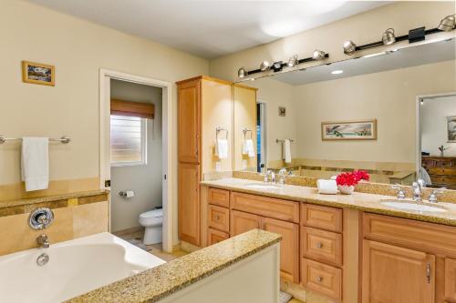 a bathroom with two sinks and a large mirror at Hale Imaka in Kipu