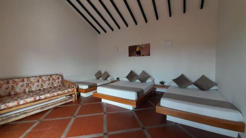 a living room with two beds and a couch at La Manola Finca Hotel in Doradal