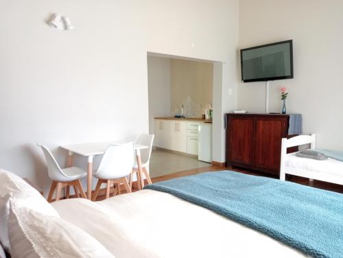 a bedroom with a bed and a table with chairs at Wapadrand Guest Suite in Pretoria