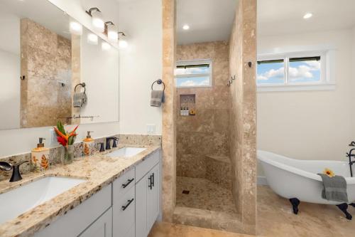 a bathroom with two sinks and a tub and a shower at Kolepa Kai in Koloa