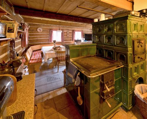 a large green stove in a kitchen with a table at Chaloupka Pod Kopřivnou in Malá Morávka