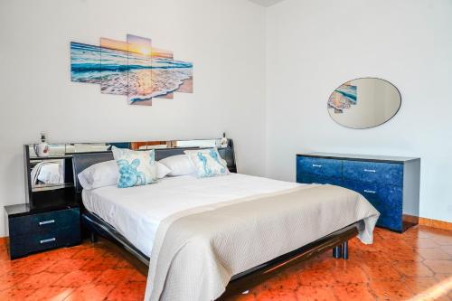a bedroom with a bed and a painting on the wall at Appartamento Marirò in Racale