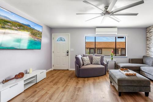 a living room with a couch and a ceiling fan at Malia Makai - D - Dolphin in Koloa