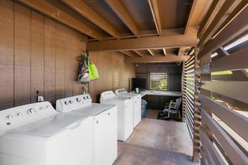a row of white washing machines in a laundry room at Malia Makai - D - Dolphin in Koloa
