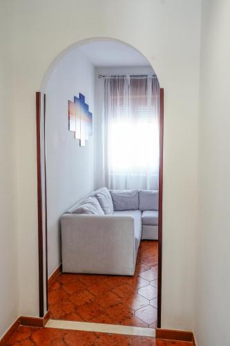 a living room with a couch in front of a mirror at Appartamento Marirò in Racale