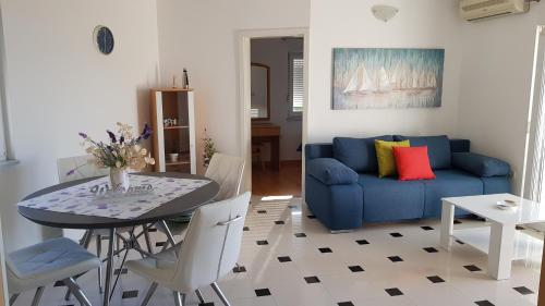 a living room with a blue couch and a table at Apartments by the sea Njivice, Krk - 5296 in Njivice
