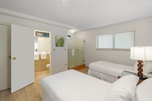 a hotel room with two beds and a bathroom at Kuhio Shores 215 in Koloa