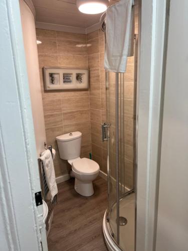 een badkamer met een toilet en een glazen douche bij city studios in Glasgow