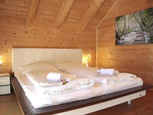 Chalet Bergoase في Elsenbrunn: سرير في غرفة خشبية عليها مناشف