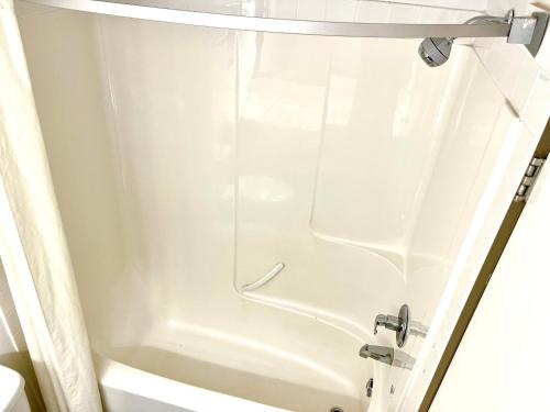 a shower in a bathroom with a white tub at Super 8 by Wyndham Hinton in Hinton