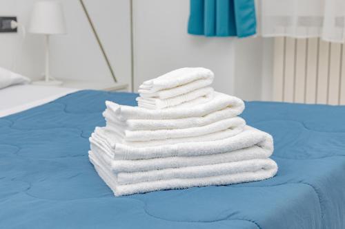 ein Stapel Handtücher auf einem Bett in der Unterkunft CasaBlanca in Lecco