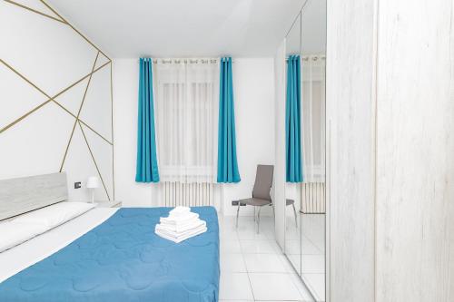 ein Schlafzimmer mit einem blauen Bett und einem Spiegel in der Unterkunft CasaBlanca in Lecco