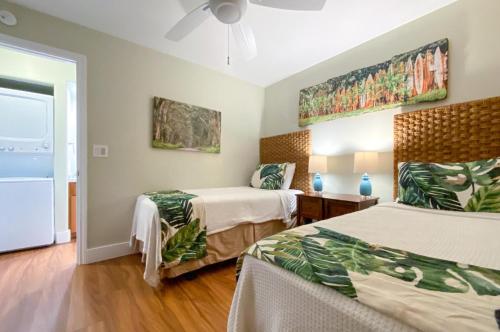 a bedroom with two beds and a ceiling fan at Poipu Shores 101A in Koloa