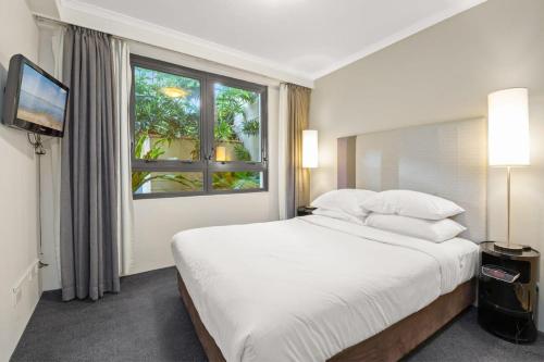 a bedroom with a large white bed and a window at Contemporary 1-Bed First Floor Unit with Pool in Sydney