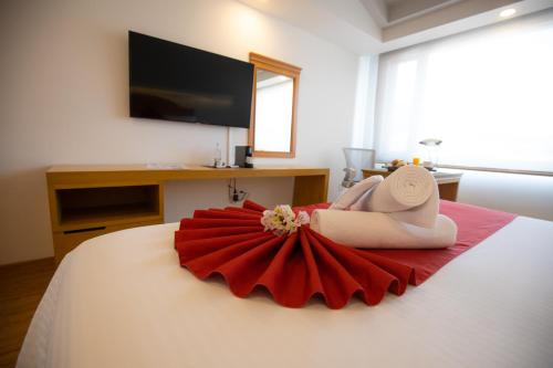 a woman laying on a bed with a red dress at Hotel Horizon & Convention Center in Morelia
