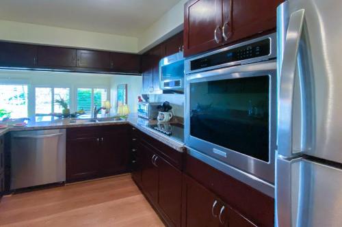 a kitchen with a stainless steel oven and a sink at Manualoha 901 Minutes to Poipu in Koloa