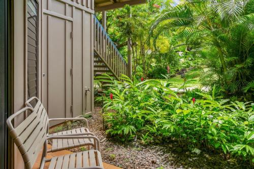 two white benches sitting on a porch with plants at Nihi Kai 509 Close to Beaches in Koloa