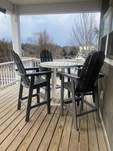 two chairs and a table on a deck at Voyage Anchor in Nags Head
