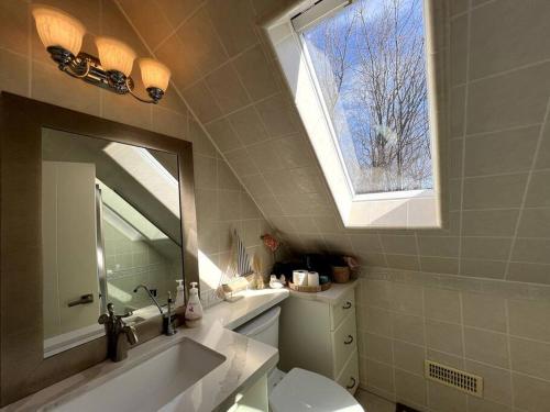 La salle de bains est pourvue d'un lavabo, de toilettes et d'une fenêtre. dans l'établissement Luxury 1000 Island's Waterfront Home, à Pittsburgh