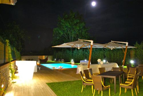 a patio with tables and umbrellas and a pool at Locanda Ristorante Gavarini in Bagnone