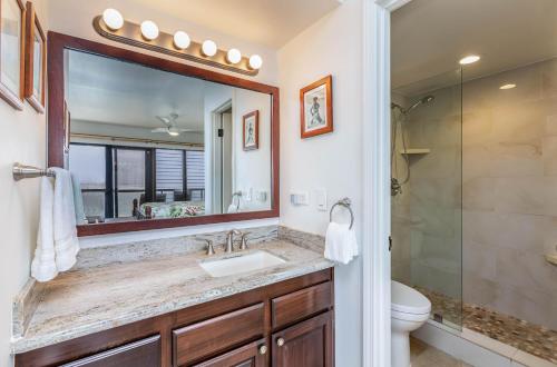 a bathroom with a sink and a mirror at Poipu Shores 207A in Koloa